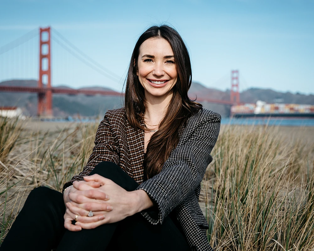 Me in a houndstooth blazer on the beach in SF, smiling